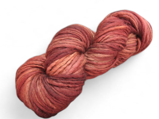 Deep crimson handspun and hand-dyed merino wool yarn, worsted weight, one ply, ideal for luxurious knitting projects.